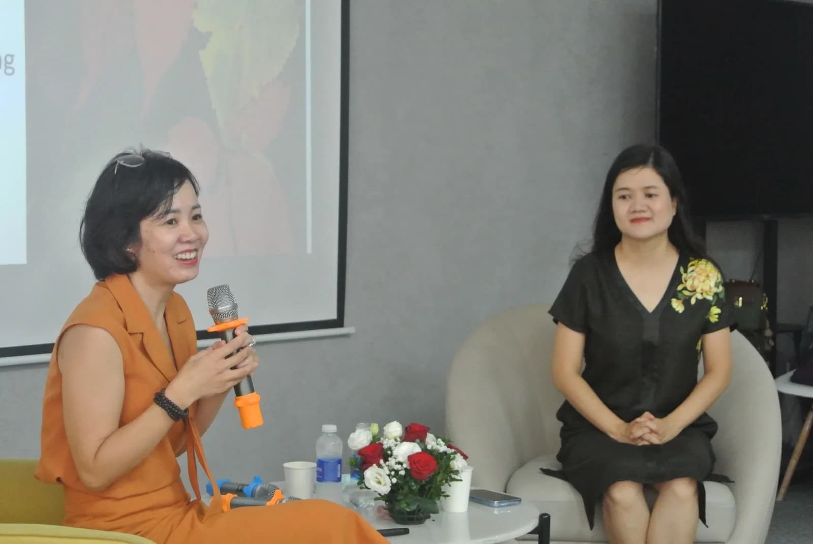 Hai người trao đổi trong một phiên chia sẻ, một người cầm micro