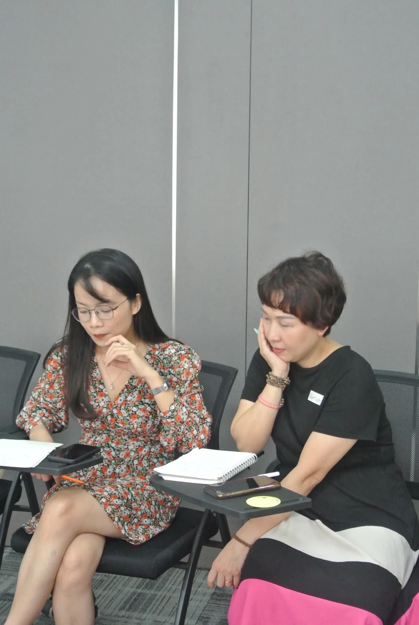 Hai học viên cùng xem lại số liệu trên tài liệu in