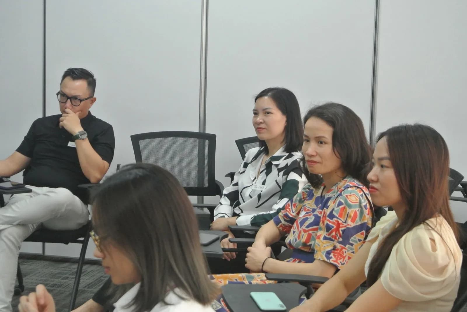Nhóm học viên ngồi thảo luận trong lớp, có tài liệu trên tay